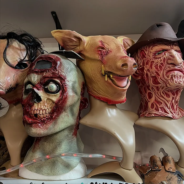 Row of horror masks: a rotting zombie, a pig and a burnt-face villain